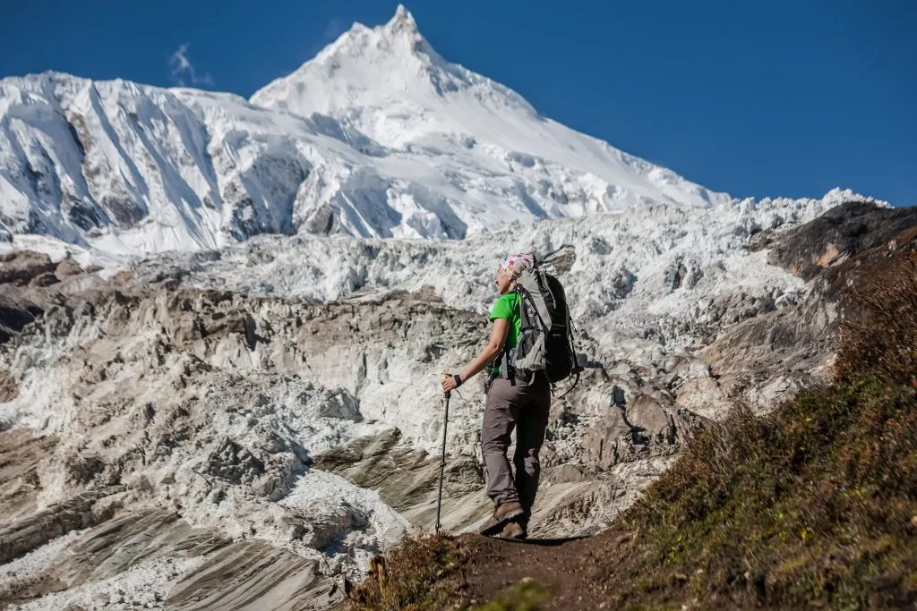 Treker před ledovcem Manaslu na treku Manaslu Circuit v Nepálu
